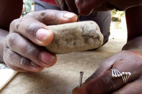 Hammering a nail with a stone